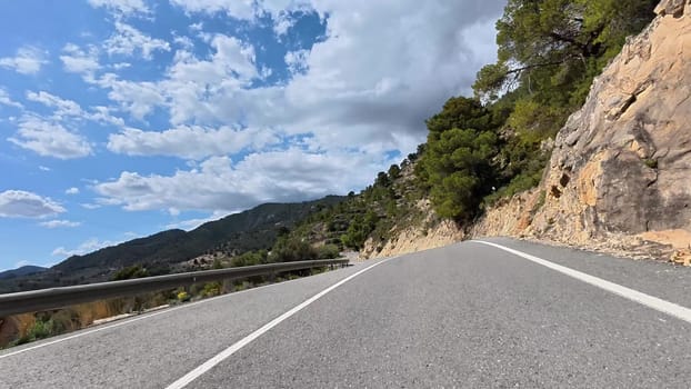 A stunningly beautiful winding road snakes through mountainous terrain, showcasing the incredible beauty of nature