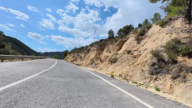 A beautiful highway winds through majestic mountains, showcasing natures beauty and clear blue skies