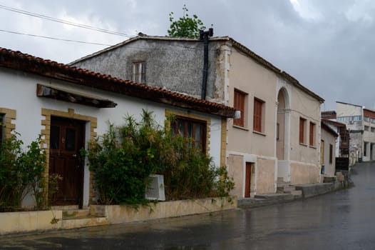Traditional Cypriot Street Under Rain with Stone Houses