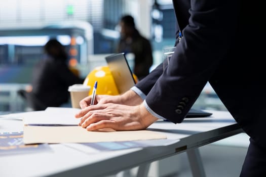 Building contractor overseeing green technology in a high tech facility, ensuring sustainability and innovation in solar panel production or infrastructure planning. Corporate oversight.