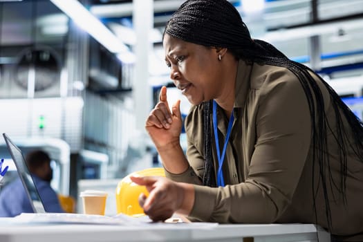 Female general manager reviewing production line system in a solar plant used for manufacturing, illustrating corporate leadership for sustainable energy in efficient industrial operations.