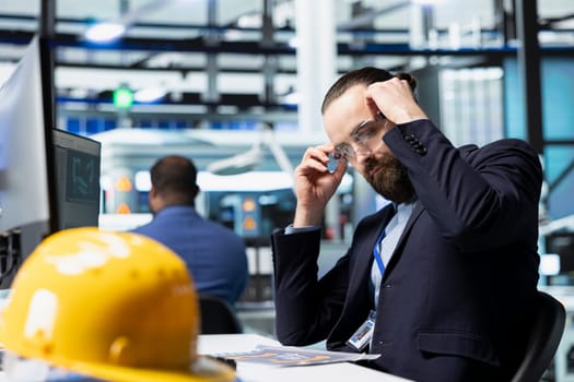 Solar power technician monitors control panels in an industrial plant, ensuring energy production runs efficiently. Male professional consultant working in a modern workplace.