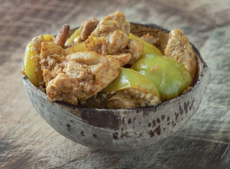 Homemade Stir fried Chicken and curry paste with Thai eggplant, Kaempfer in Coconut bowl. Stir fried Green brinjal (Round eggplant) with Chicken, use it as your Wallpaper, Poster and Copy space, Selective focus.