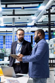Group of industry experts and engineers analyzing solar panel systems during a production inspection, ensuring engineering accuracy, quality control and factory operations efficiency.