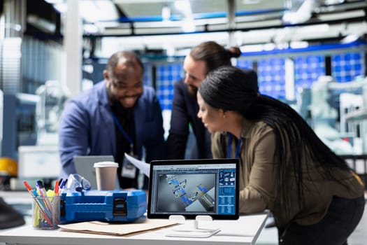 Multiethnic business associates and engineers gather for a discussion in a solar tech manufacturing facility, planning future developments in sustainable energy and industrial operations.