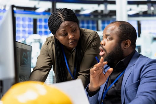African American professional team working together in a solar plant, uniting forces to ensure efficient production of clean energy technology. Managing photovoltaics manufacturing.