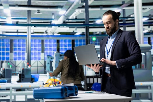 Engineer consultant in formal attire evaluates factory workflow, combining business expertise and industrial efficiency in solar tech manufacturing industry. Clean energy and innovation.
