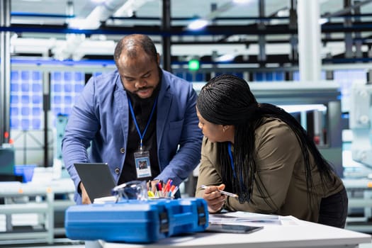 Black industry engineers team working together on solar panel systems during a production inspection, ensuring engineering accuracy, quality control and factory operations efficiency.