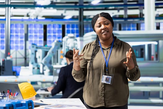 Black woman inspector explaining the new photovoltaics production, obtaining cheaper eco friendly energy. Female manager discussing about alternative energy for business development.