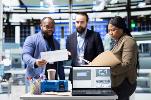 Diverse team of professional engineers and analysts discuss improvements in solar tech manufacturing process, advancing renewable energy through shared insight and industrial innovation.
