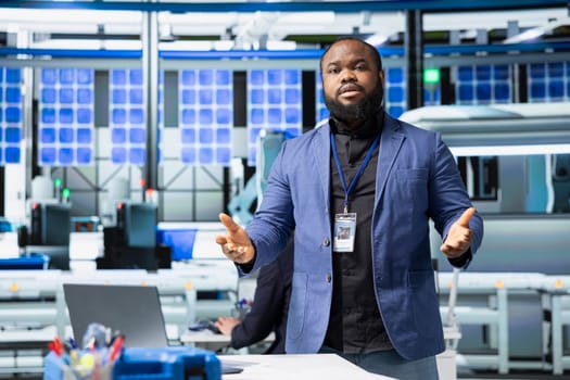 Black director hosting a meeting to discuss renewable energy production, ensuring quality control tests and sustainable solutions for cheaper solar power. Manage industrial operations.