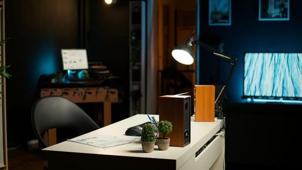 Stylish home office in a modern loft apartment with cozy creative workspace with wooden furniture, house plants and a TV in a spacious living room. Perfect for a comfortable, urban lifestyle.