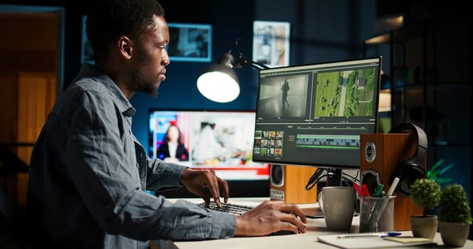 African american videographer works on editing film footage at home, doing freelance contract for post production scenes. Editor correcting white balance and color grading, pc software. Camera A.