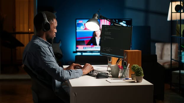 Young programmer engineer writing binary code data on terminal window, doing freelance work at home setup. Software developer working on troubleshooting with programming language. Camera B.