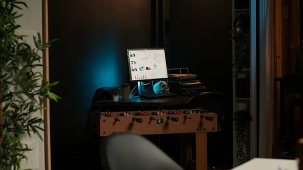 Cozy loft style illuminated apartment with a modern home office. The space features wooden furniture, decorative plants and a TV combining stylish interior design with functional workspace.