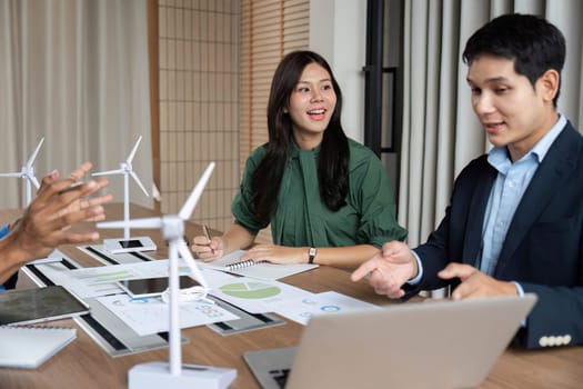 A diverse team discusses renewable energy solutions during an ESG strategy meeting, showcasing commitment to sustainability.