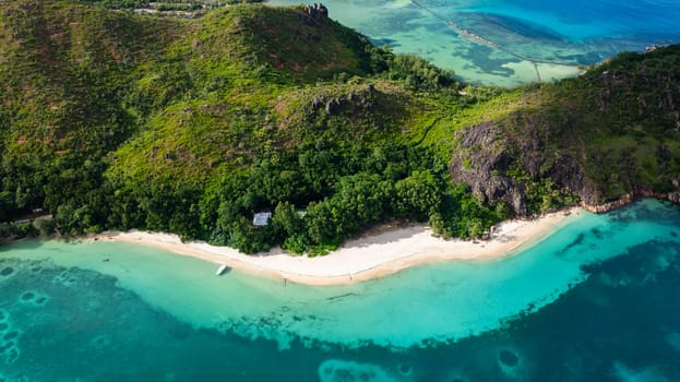 A hidden tropical beach surrounded by dense green hills and turquoise waters. Curieuse, Seychelles.