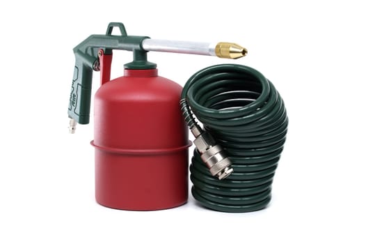 Detailed close-up view of a green and red compressed air tool with coiled hose, ideal for industrial and household applications, placed isolated on clean white surface highlighting its compact design