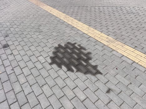 Leakage or leakage of oil from the car engine onto the paving slabs in a parking space, checking and maintaining the car in a car service center, engine breakdown. High quality photo