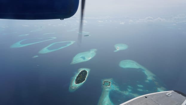 Stunning aerial view of the maldives islands, a tropical paradise with crystal-clear turquoise waters, white sandy beaches, and lush green vegetation, seen from a seaplane