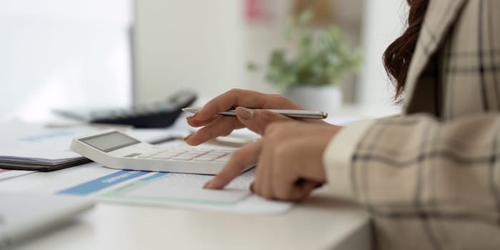 A business professional using a calculator to analyze financial data, emphasizing accuracy in accounting tasks.