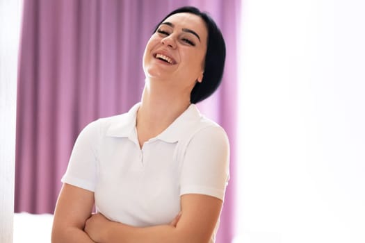Confident Female Healthcare Worker. Portrait of a confident young female healthcare worker in a white uniform standing with arms crossed.