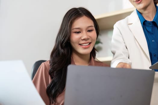A businesswoman shares insights with her colleague, fostering a positive interaction in a stylish office environment.