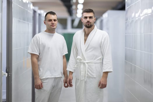 Medical Consultation in Spa Corridor.Two men discussing treatment options while walking through a clinical spa corridor, wearing white uniforms and bathrobe