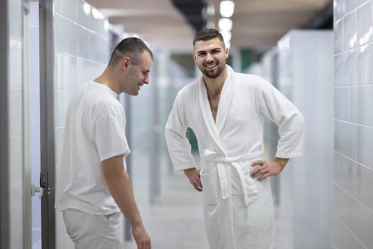 Medical Consultation in Spa Corridor.Two men discussing treatment options while walking through a clinical spa corridor, wearing white uniforms and bathrobe