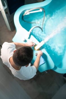 A therapist preparing a hydrotherapy bathtub for a patient inside a tiled wellness room. Spa Therapist Adjusting Tub