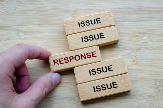 Issue and Response Dynamics highlighting how challenges are met with strategic responses, depicted on stacked wooden blocks.