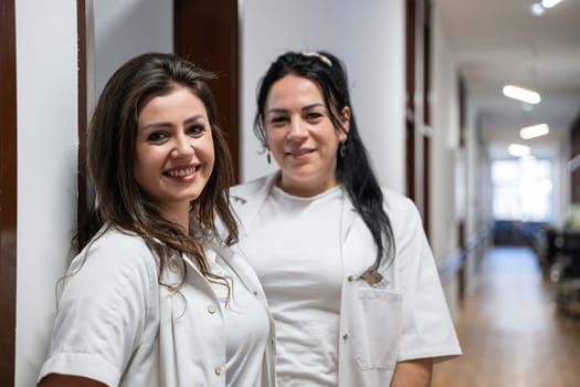 Two nurses take a well deserved break in the hospital hallway, resting after a long and demanding day of patient care
