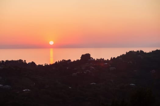 Beautiful tourist landscape sunset over the sea from a mountain valley.