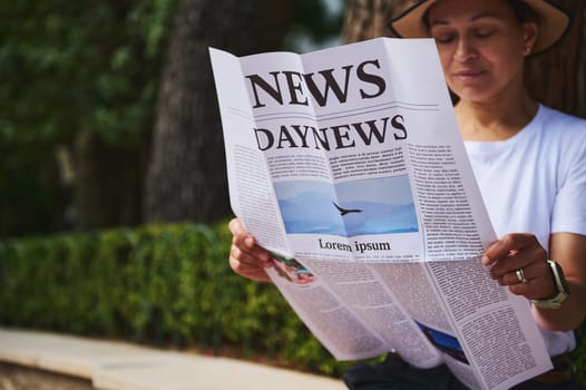 Individual engaged in text reading while seated outdoors amid a natural, serene backdrop, emphasizing relaxation and informative media consumption.