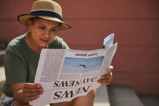 Casual scene depicting a woman in a sunhat reading a newspaper outdoors. Concept of staying informed, enjoying leisure activities, and intellectual engagement.