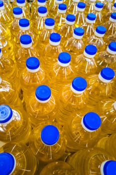 stack of bottles with sunflower seed oil at the grocery store, full-frame closeup view