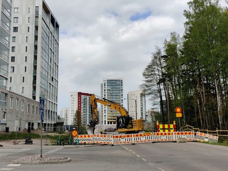 Espoo, Finland - JUNE 4th, 2025: Meritie construction in the city of Espoo, Finland, Finnoo metro station. Excavators are digging the road. The area is closed with construction barriers