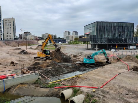 Espoo, Finland - JUNE 4th, 2025: Meritie construction in the city of Espoo, Finland, Finnoo metro station. Excavators are digging the road. The area is closed with construction barriers