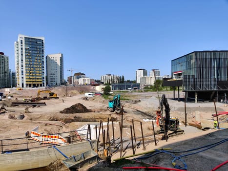 Espoo, Finland - JUNE 4th, 2025: Meritie construction in the city of Espoo, Finland, Finnoo metro station. Excavators are digging the road. The area is closed with construction barriers