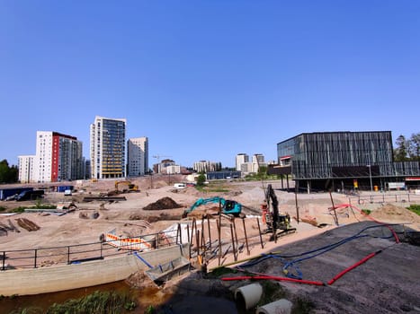 Espoo, Finland - JUNE 4th, 2025: Meritie construction in the city of Espoo, Finland, Finnoo metro station. Excavators are digging the road. The area is closed with construction barriers