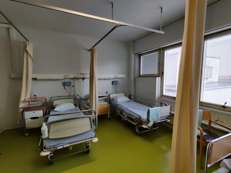 Espoo, Finland - April 14, 2025: hospital room at Jorvi Hospital or Jorvinsairaala, hospital beds with side rails, medical equipment, and a bedside table, typical modern Finnish public healthcare facilities