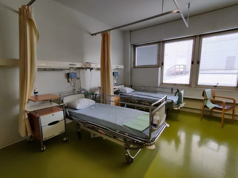 Espoo, Finland - April 14, 2025: hospital room at Jorvi Hospital or Jorvinsairaala, hospital beds with side rails, medical equipment, and a bedside table, typical modern Finnish public healthcare facilities