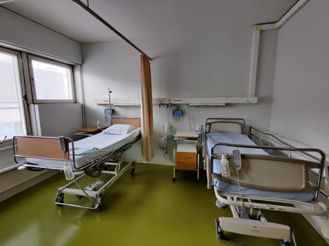 Espoo, Finland - April 14, 2025: hospital room at Jorvi Hospital or Jorvinsairaala, hospital beds with side rails, medical equipment, and a bedside table, typical modern Finnish public healthcare facilities