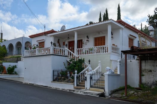 Peaceful street in Lefke lined with old-style homes, wooden balconies, and flowering plants.