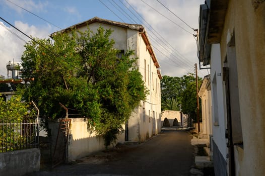 Quaint Cypriot street in Lefke with stone houses and balconies, showcasing local architecture and charm.