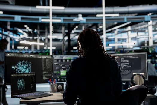 Data center admin looks at AI visualization dashboard on laptop to pinpoint equipment performance issues. Server farm specialist looks at data analysis graph on notebook to reduce hardware failures
