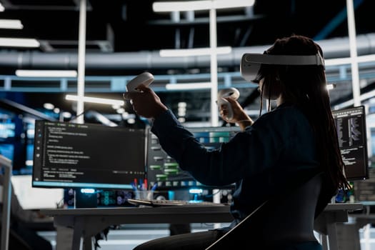 Data center admin using virtual reality to setup machine learning systems handling information. IT specialist using VR headset to train neural networks to improve server farm operations