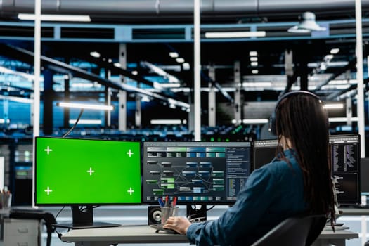 Programmer in data center using isolated screen computer to check equipment performance upgrading infrastructure. IT expert doing maintenance on supercomputers in servers room using chroma key PC