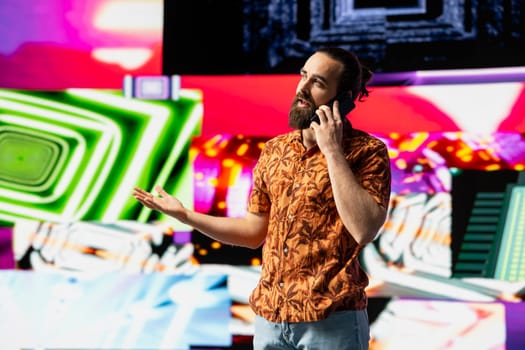 Stylish vlogger and DJ answers a phone call under vibrant neon lights, nightlife vibe with music culture, visuals and urban ambiance for social media or digital streaming. Cool creative guy.