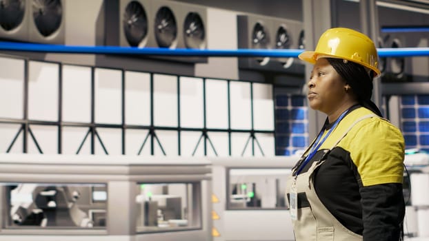Smart factory mechanic installing automated workflows control systems, computerizing operations. Repairman walking in industry 4.0 plant with toolbox, integrating sensors into production, camera B